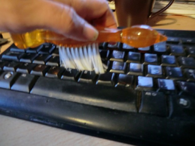Image:  Cleaning a keyboard with a brush.