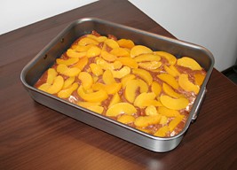 Pour the mix into a baking tray and top with the peach slices