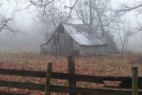 An old barn surrounded by fog