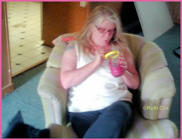 Ruthi sips a smoothie with a glass straw.