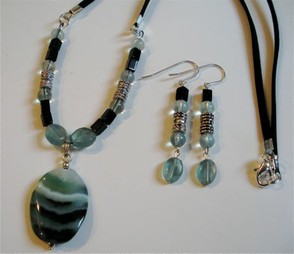 Light blue-green fluorite mixed with banded onyx, suede and metal findings.