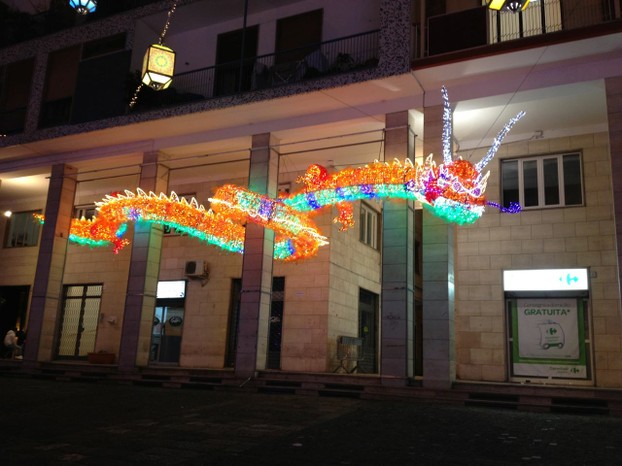 A colorful Chinese dragon weaves his way around a building front in Salerno.
