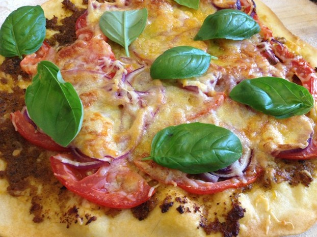 Homemade pizza with red pepper pesto and fresh tomatoes