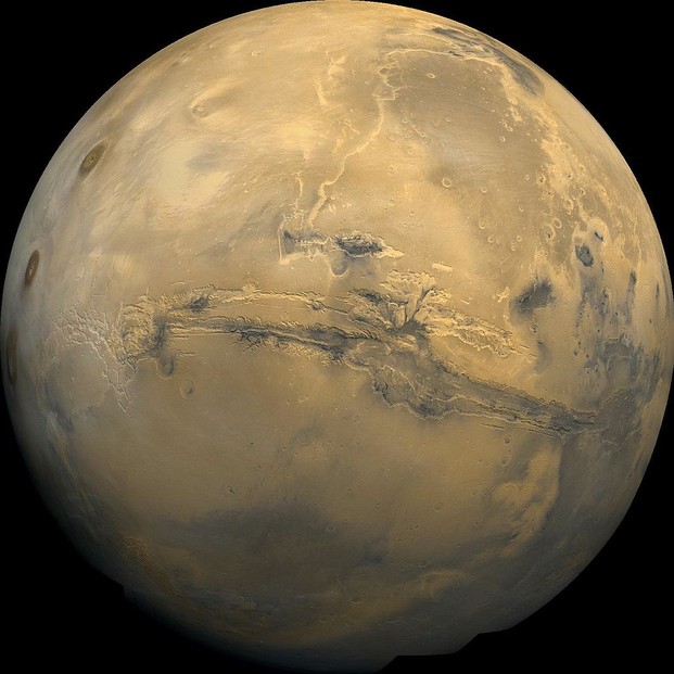 Valles Marineris, largest Martian canyon system (center), and Tharsis Montes, three large shield volcanoes (center left to upper left)