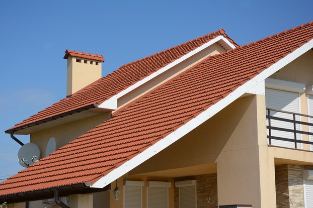 House with clay tile roof, rain gutter, chimney, gable and valley type of roof construction