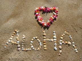 aloha in shells on beach with lei
