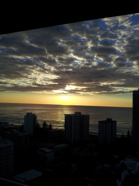 Sun Breaks Through Dark Clouds at Sunrise at Surfers Paradise