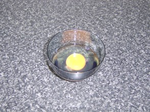 The egg is broken in to a small bowl