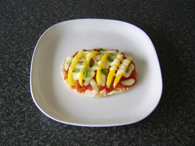 A clean and simple yellow pepper and tomato herb pizza