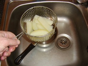 The wire basket is simply lifted from the water to drain the chips