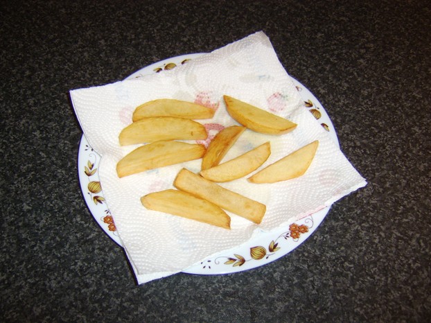 The twice fried chips are drained on kitchen paper prior to service