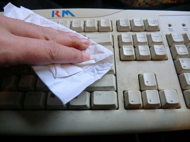 Image: Wiping a keyboard with a paper towel.