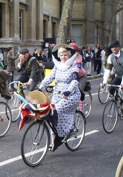 Lady in vintage clothing on classic bike