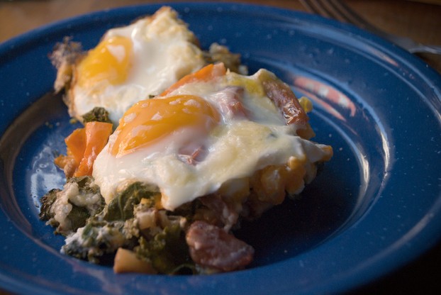 Shredded cheese and fried or poached eggs are popular toppers for the tasty trio of kale, potatoes, and tomatoes.