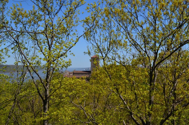 Through the trees, one can see the Cloisters in the distance.