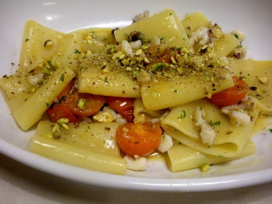 Pasta prepared with cherry tomatoes and pistachio nuts, as served in Milan, Italy.