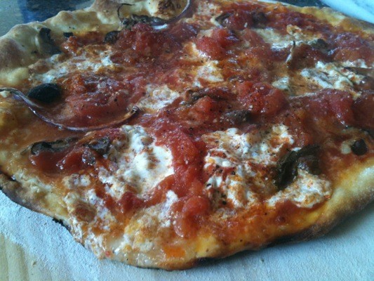 Homemade pizza with San Marzano tomatoes, mozzarella cheese, and anchovies