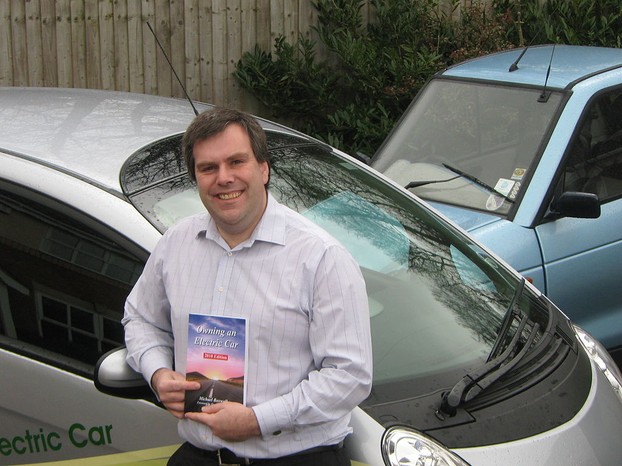 Michael Boxwell rests against Mitsubishi electric car; Thursday, February 11, 2010, 12:11