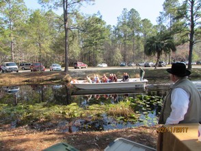A tour boat passes local historian and author, Luther Thrift, on Pioneer Island.
