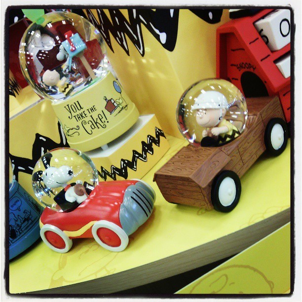Hallmark snow globes of Charlie Brown and Snoopy in You Take the Cake and of Charlie and Snoopy driving cars